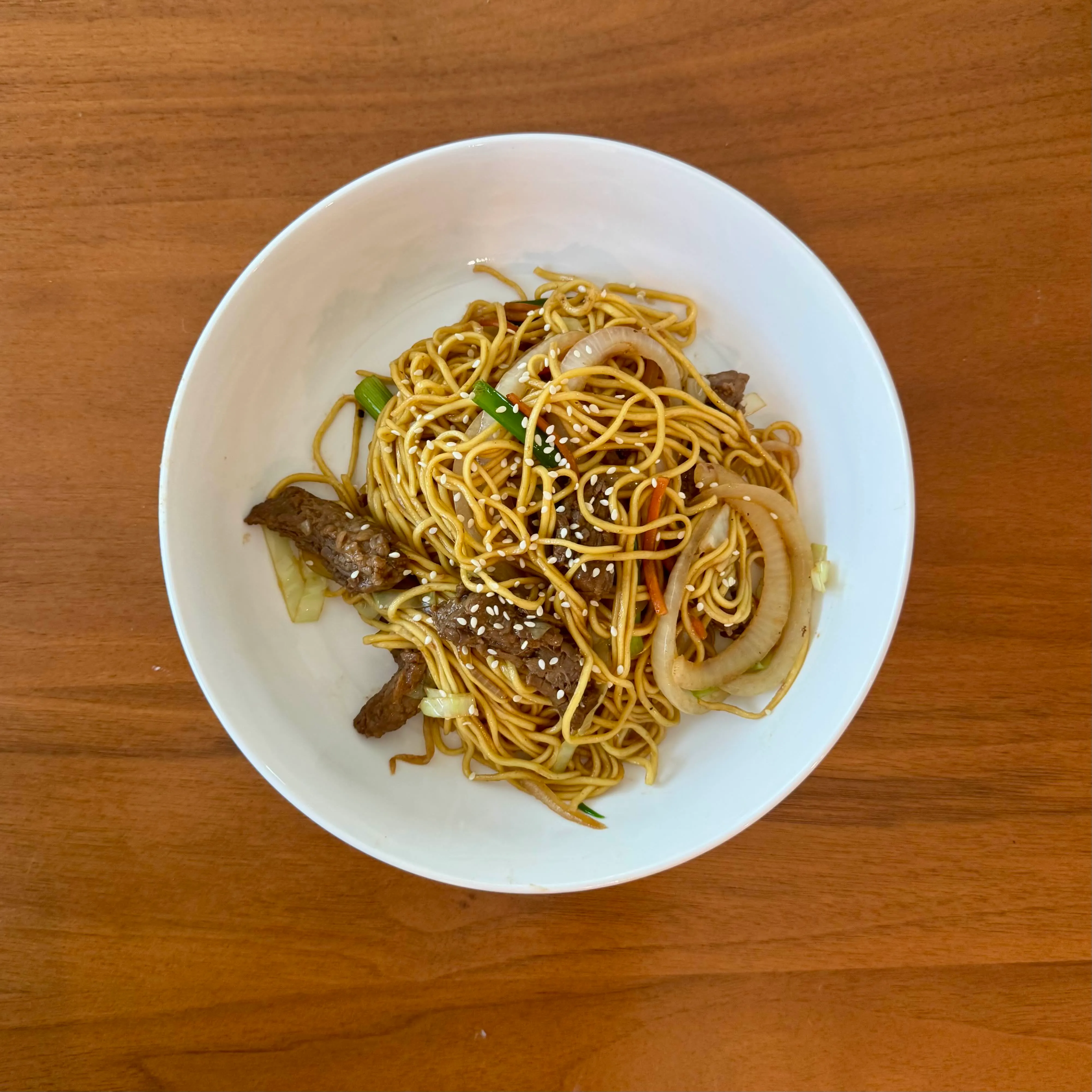 Beef lo mein - thin noodles with strips of beef, onion, and carrot matchsticks, dusted with sesame.